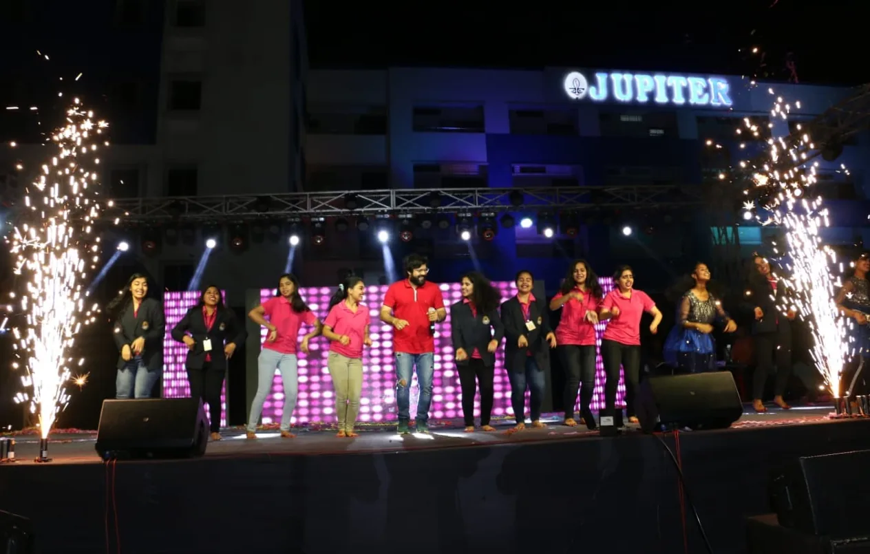 Performers on an illuminated stage with fireworks at the Jupiter Group’s 20-year celebration.